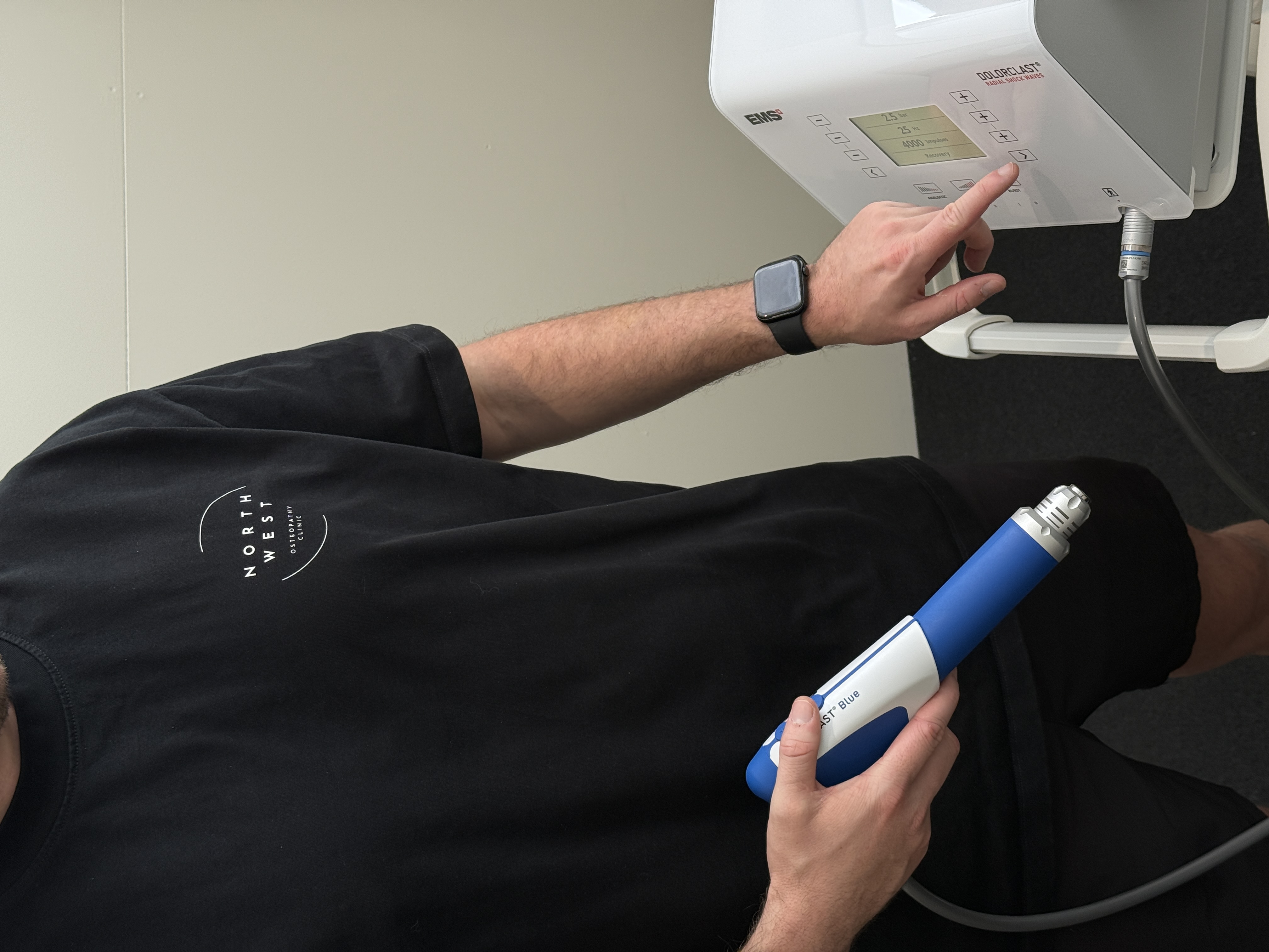 Brayden adjusting the clinic’s shockwave therapy equipment